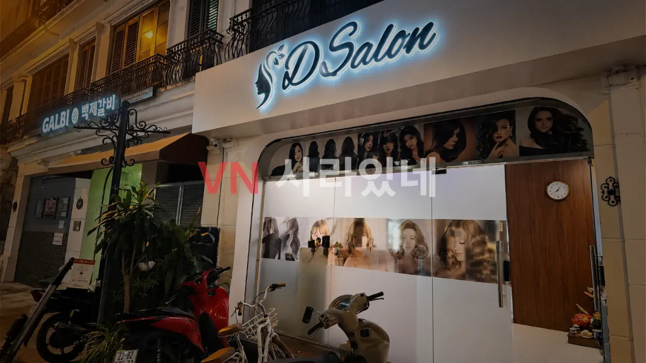 하노이 디 살롱 마사지 외관 야경 — D Salon 간판·여성 포스터 유리창·옆 백제갈비 식당